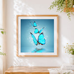 Finished glowing blue butterflies over water cross stitch artwork displayed