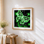 Glowing green crystal butterfly cross stitch artwork displayed on wall as home decor