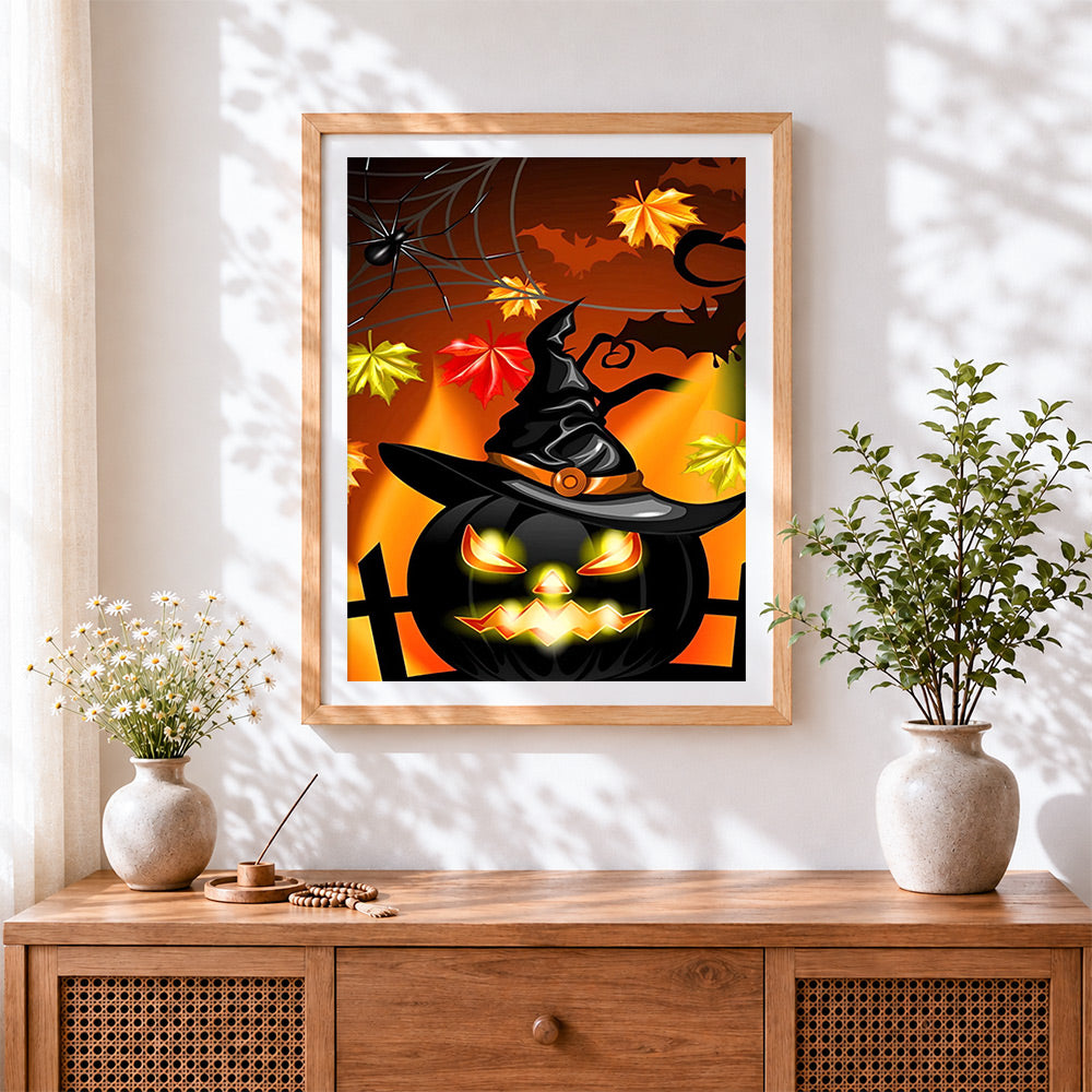 Finished glowing jack-o'-lantern with witch hat cross stitch artwork displayed