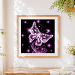 Finished glowing purple crystal butterfly cross stitch artwork displayed