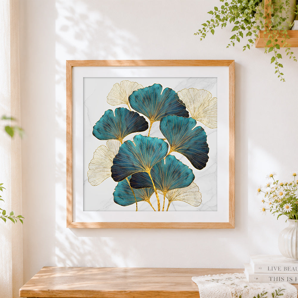 Finished gold and teal ginkgo leaves on marble cross stitch artwork displayed