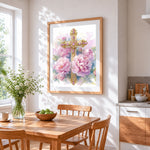 Gold cross with pink peonies cross stitch artwork displayed on wall as home decor