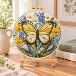 Golden butterfly with daisies embroidery kit finished hoop displayed on a wooden stand as cozy tabletop decor