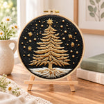 Golden festive tree embroidery kit finished hoop displayed on a wooden stand as cosy tabletop decor