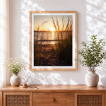 Finished golden hour beach grass silhouette cross stitch artwork displayed