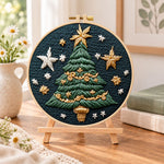Golden star christmas tree embroidery kit finished hoop displayed on a wooden stand as cosy tabletop decor