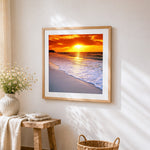Golden sunset over ocean cross stitch artwork displayed on wall as home decor