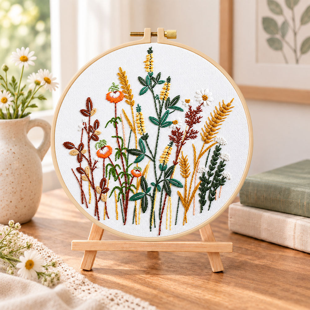 Golden wheat and poppy blooms embroidery kit finished hoop displayed on a wooden stand as cosy tabletop decor