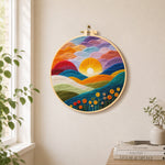 Gradient clouds, bright yellow sunset and colourful hills needle felt wall art displayed in a bright home interior