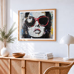 Graffiti style woman in red sunglasses cross stitch artwork displayed on wall as home decor