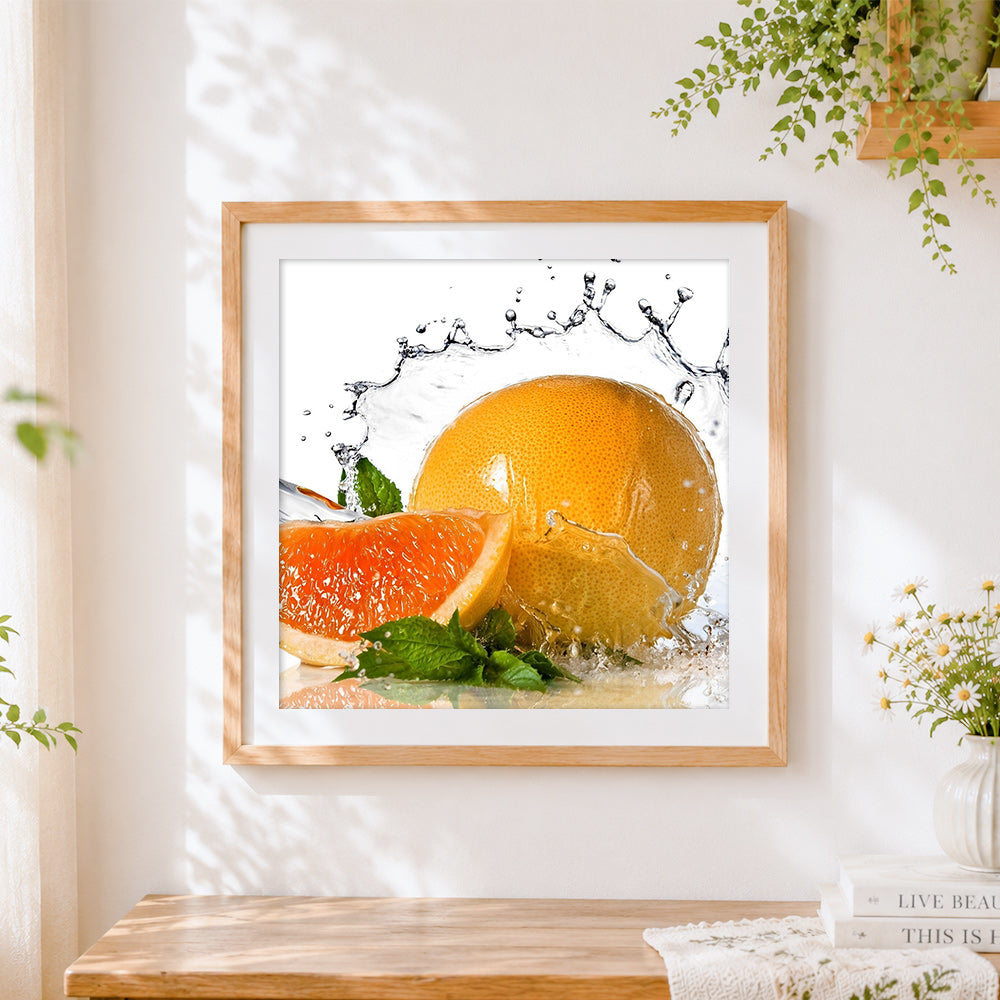 Finished grapefruit and water splash cross stitch artwork displayed