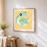 Green t-rex dinosaur cross stitch artwork displayed on wall as home decor