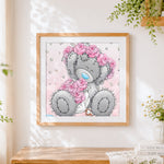 Finished grey bear with pink rose cross stitch artwork displayed