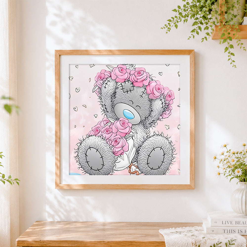 Finished grey bear with pink rose cross stitch artwork displayed
