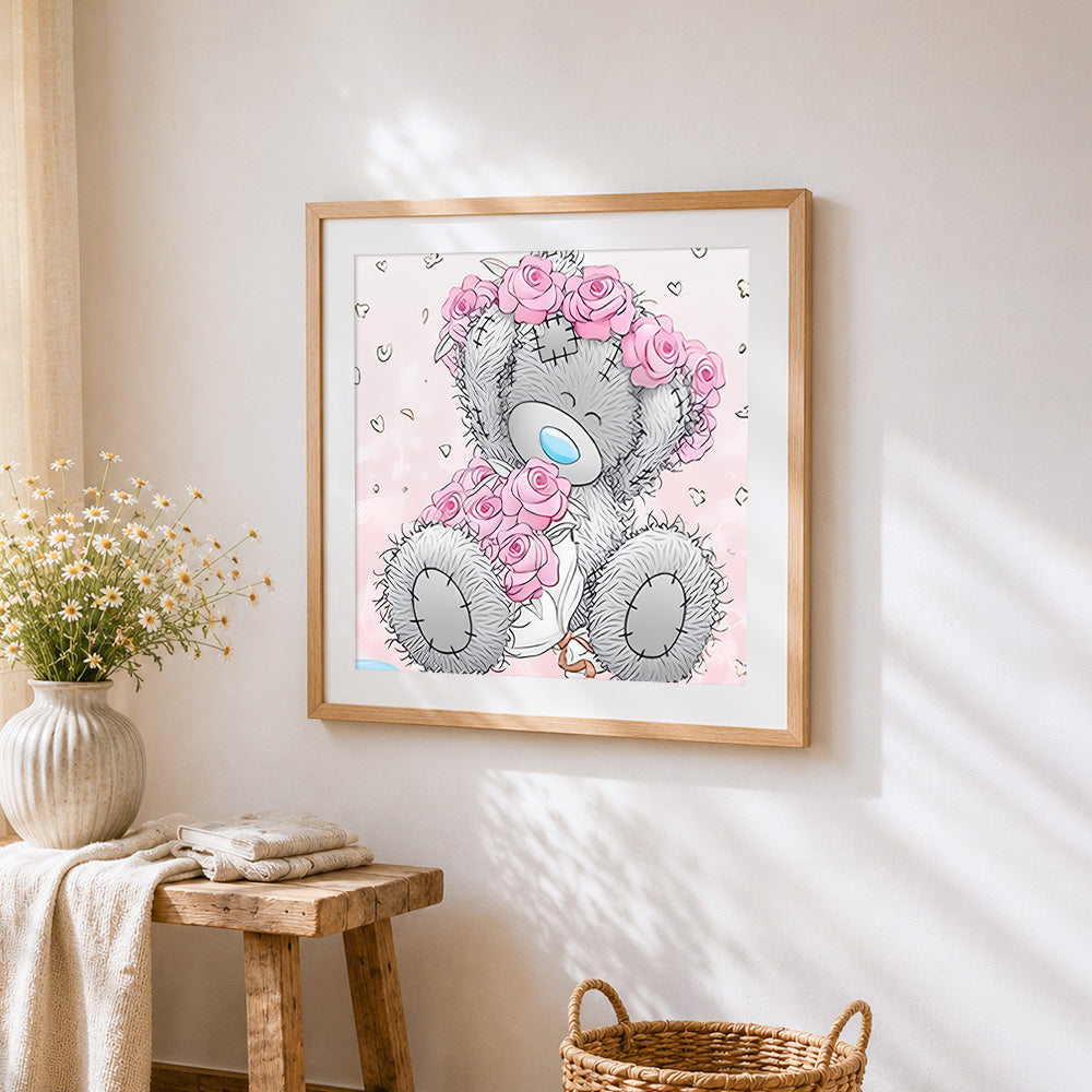 Grey bear with pink rose cross stitch artwork displayed on wall as home decor