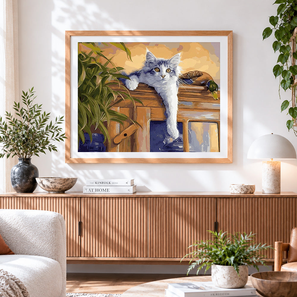 Finished grey cat lounging on a cabinet cross stitch artwork displayed