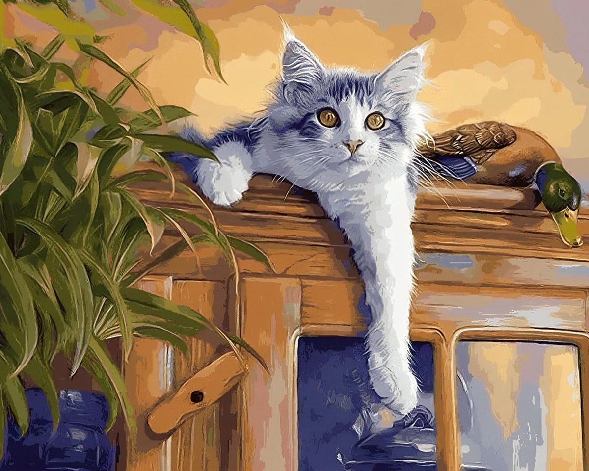 Grey cat lounging on a cabinet cross stitch kit for beginners
