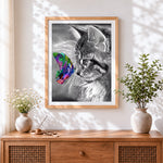 Finished grey cat with a colourful butterfly cross stitch artwork displayed