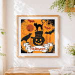 Finished halloween black cat and pumpkin cross stitch artwork displayed