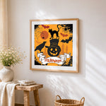 Halloween black cat and pumpkin cross stitch artwork displayed on wall as home decor