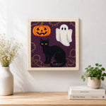 Finished halloween cat and ghost artwork displayed on a wall