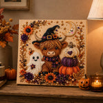 Finished halloween highland cow and ghost pearl diamond painting artwork displayed as holiday home decor