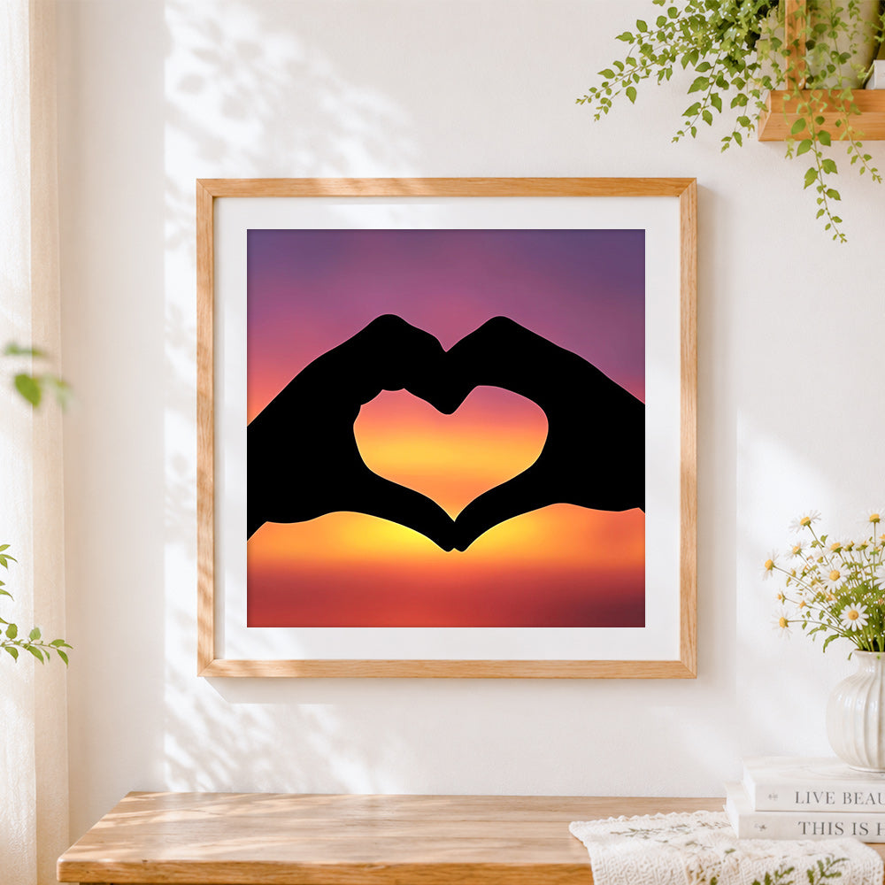 Finished hands making a heart at sunset cross stitch artwork displayed