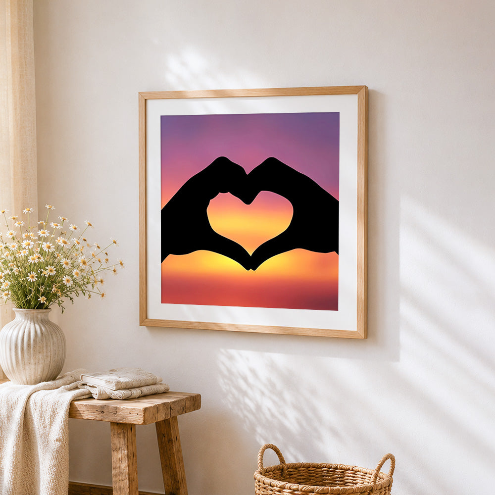 Hands making a heart at sunset cross stitch artwork displayed on wall as home decor
