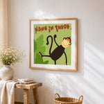 "Hang in there" cartoon monkey cross stitch artwork displayed on wall as home decor