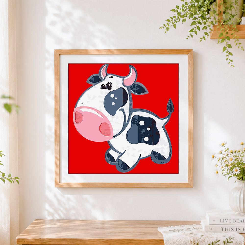 Finished happy jumping cow cross stitch artwork displayed