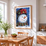 Happy snowman with poinsettia hat cross stitch artwork displayed on wall as home decor