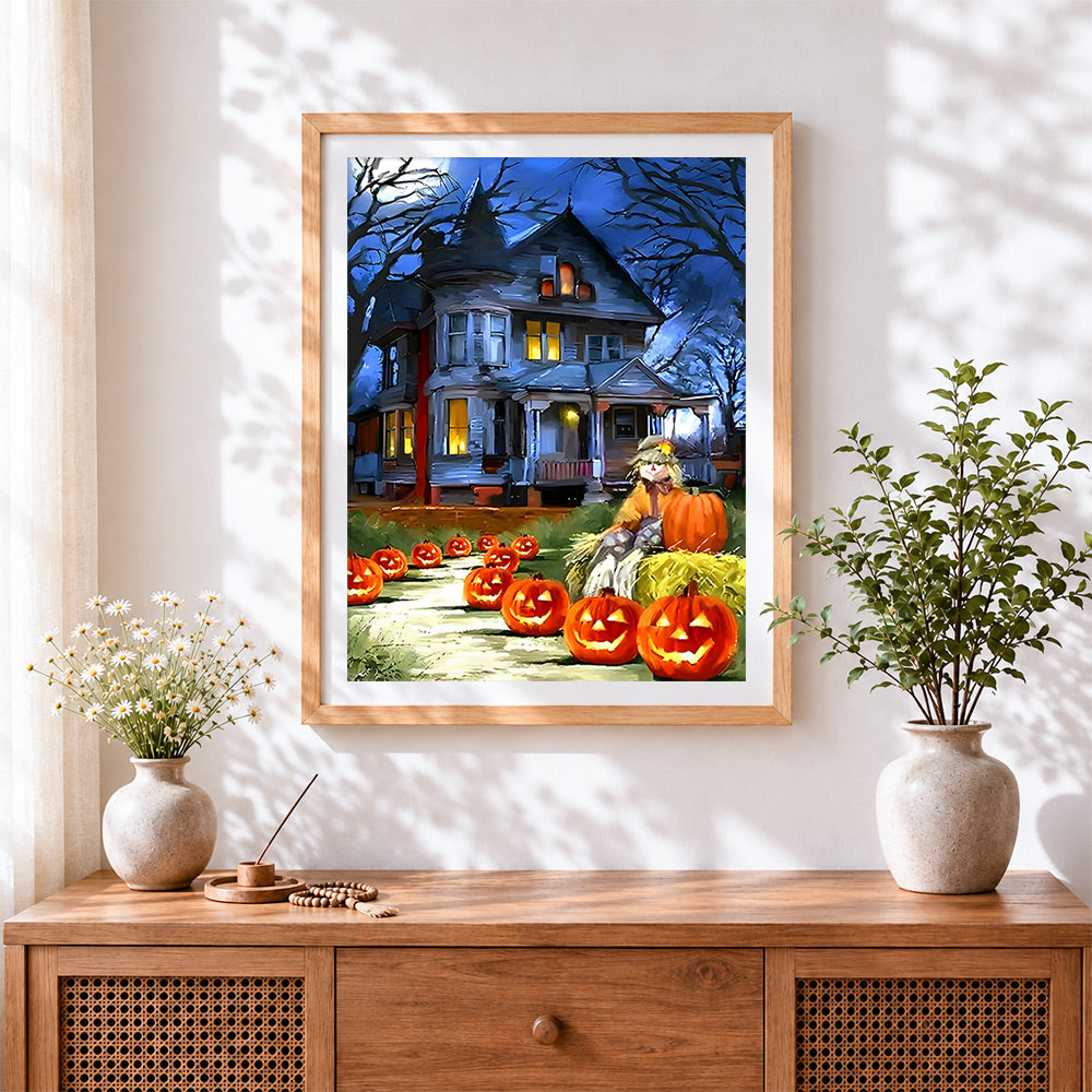 Finished haunted house and glowing pumpkins cross stitch artwork displayed