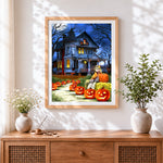 Finished haunted house and glowing pumpkins cross stitch artwork displayed