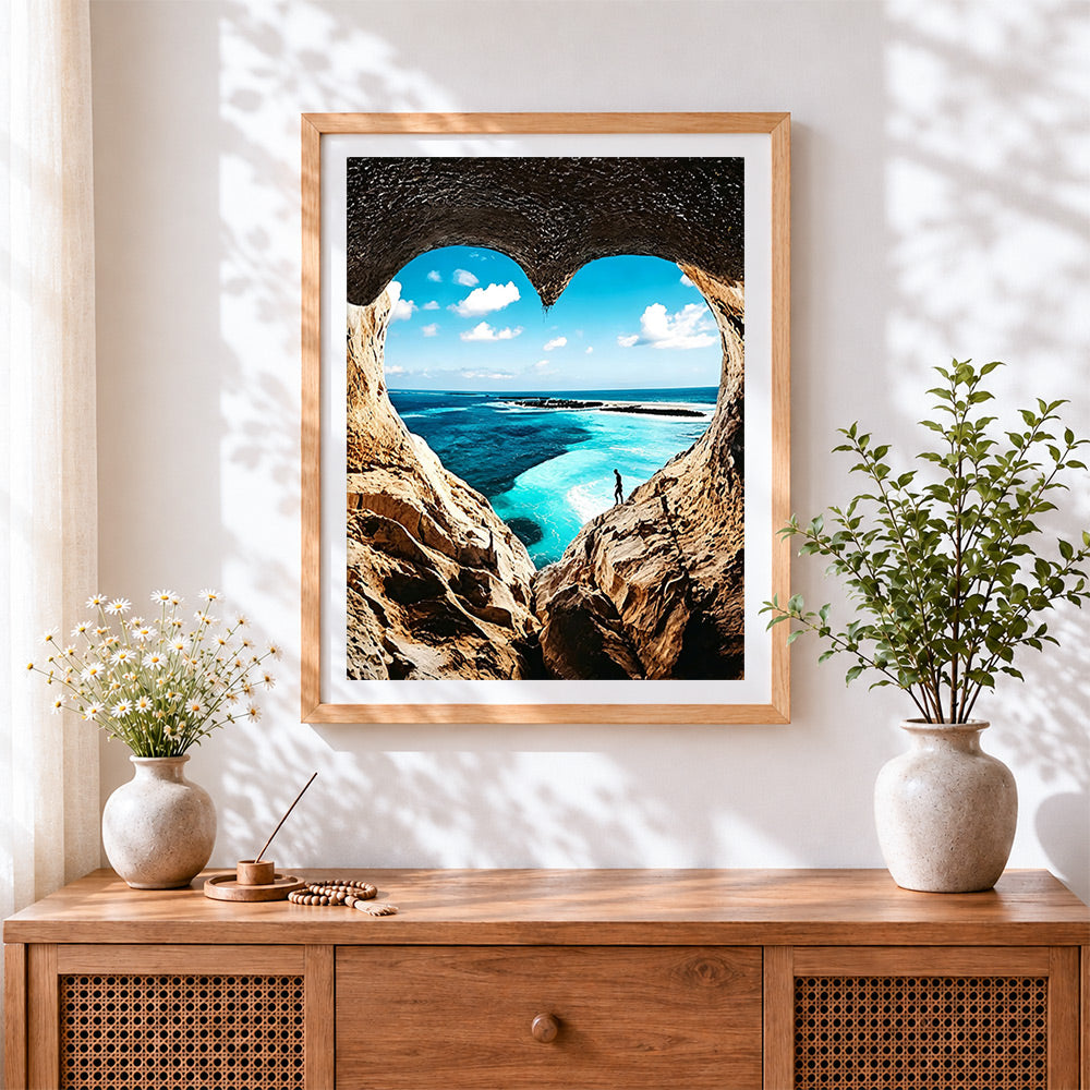 Finished heart shaped cave ocean view cross stitch artwork displayed