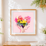 Finished heart-shaped flower bouquet in hands cross stitch artwork displayed