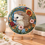 Hedgehog with sunflower blooms embroidery kit finished hoop displayed on a wooden stand as cozy tabletop decor