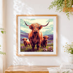 Finished highland cow family in the mountains cross stitch artwork displayed