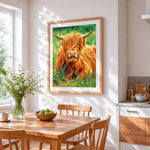 Highland cow in grass cross stitch artwork displayed on wall as home decor