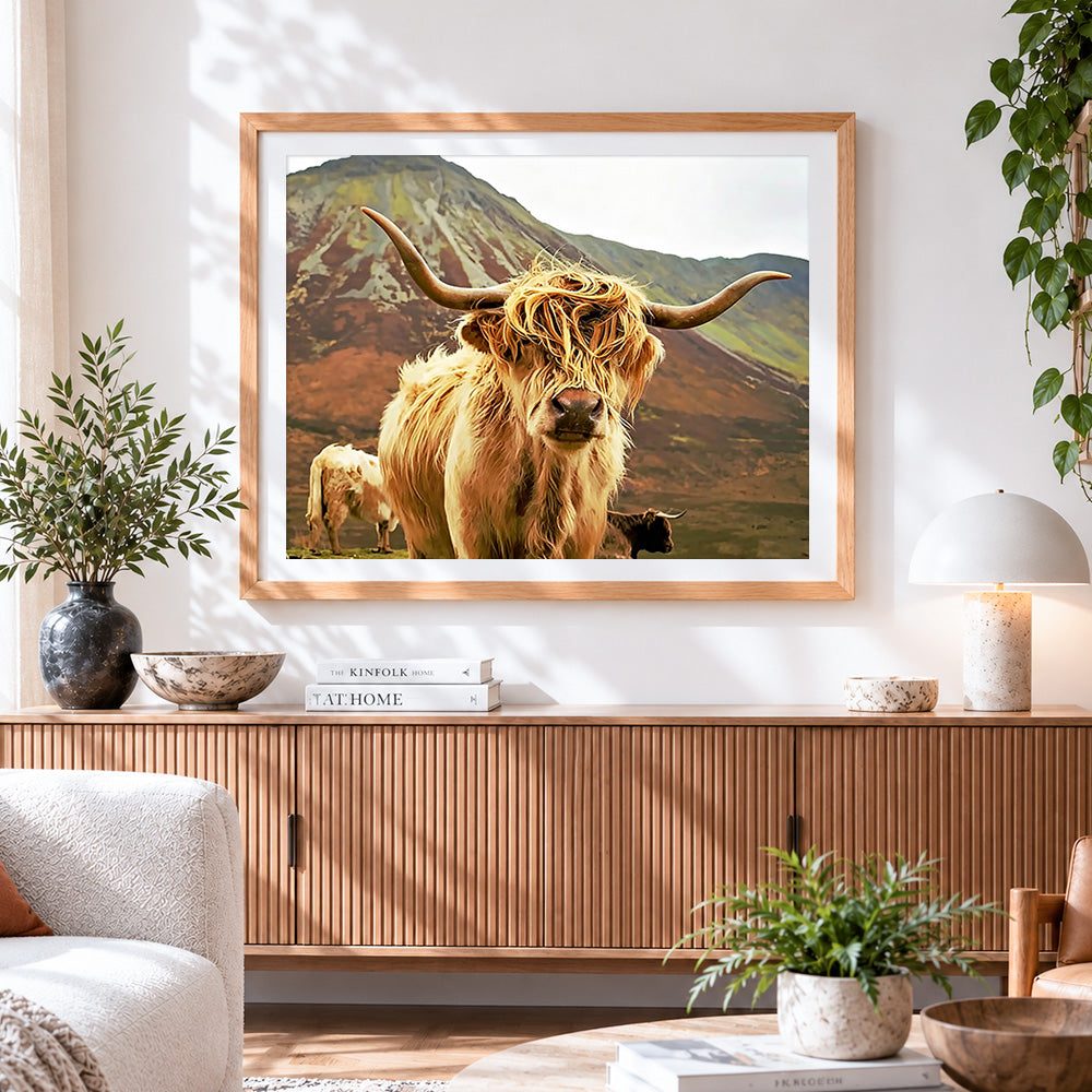 Finished highland cow in mountains cross stitch artwork displayed