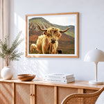 Highland cow in mountains cross stitch artwork displayed on wall as home decor