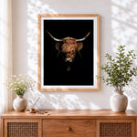 Finished highland cow on black background cross stitch artwork displayed