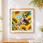 Finished highland cow surrounded by sunflowers cross stitch artwork displayed