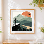 Finished hiker on cliff at sunset cross stitch artwork displayed