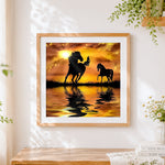 Finished horse silhouettes at sunset cross stitch artwork displayed