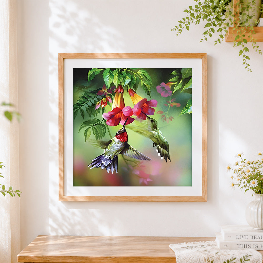 Finished hummingbirds and trumpet flowers cross stitch artwork displayed
