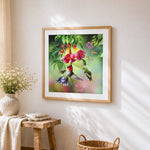 Hummingbirds and trumpet flowers cross stitch artwork displayed on wall as home decor