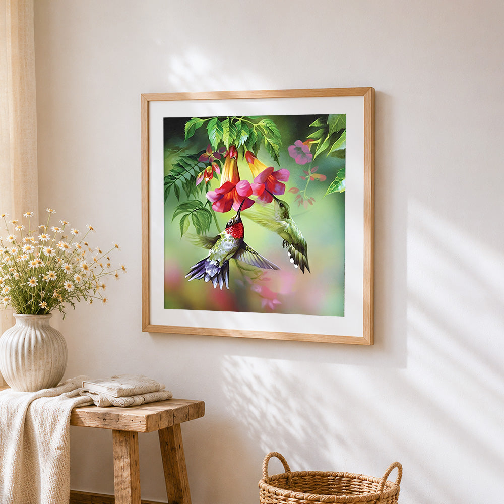 Hummingbirds and trumpet flowers cross stitch artwork displayed on wall as home decor