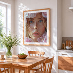 Hyperrealistic blue eyed woman cross stitch artwork displayed on wall as home decor