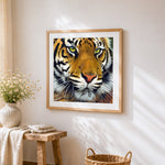 Intense bengal tiger face close-up cross stitch artwork displayed on wall as home decor