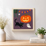 Finished jack o lantern and cat artwork displayed on a wall